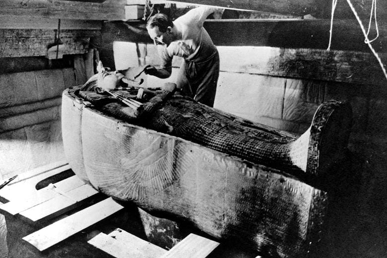 Archaeologist Howard Carter examines King Tutankhamen's tomb in November 1922.   (Public Domain / Photo by Harry Burton for the New York Times.) 